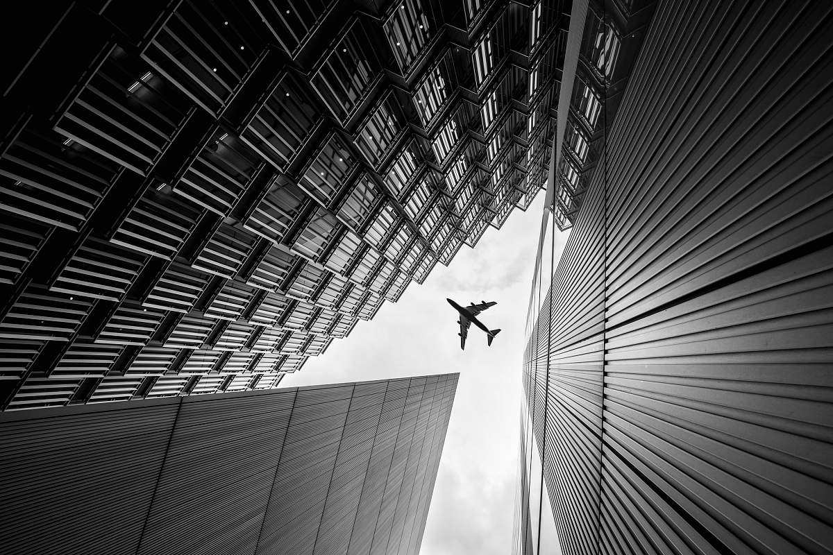 high rise airplane on sky black-and-white